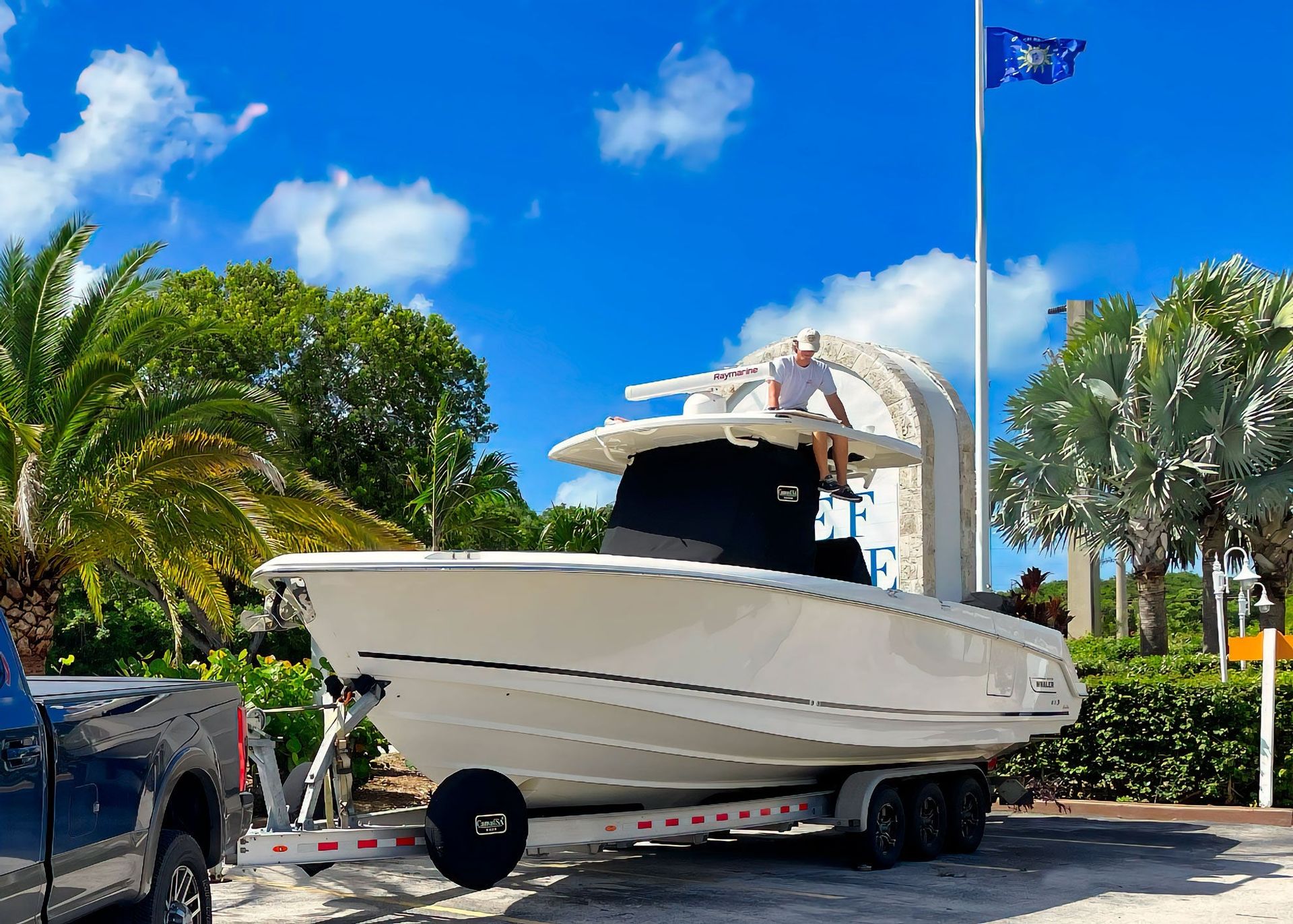 A Boston Whaler on its trailer with a fitted black Canvas USA® T-top console cover and spare tire cover