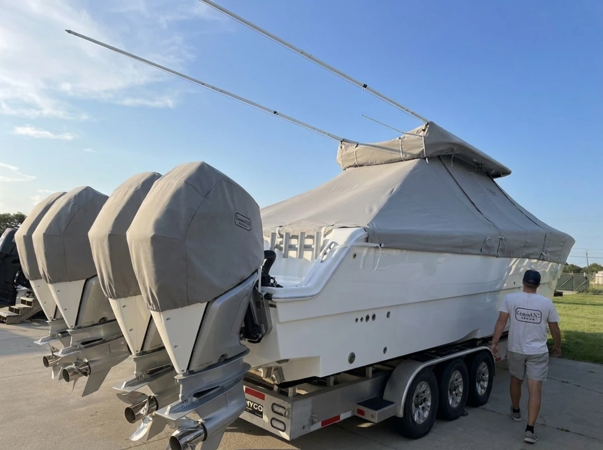 A Freeman 38 under a fitted gray Canvas USA® full boat cover, each of its four outboards in its own motor cover