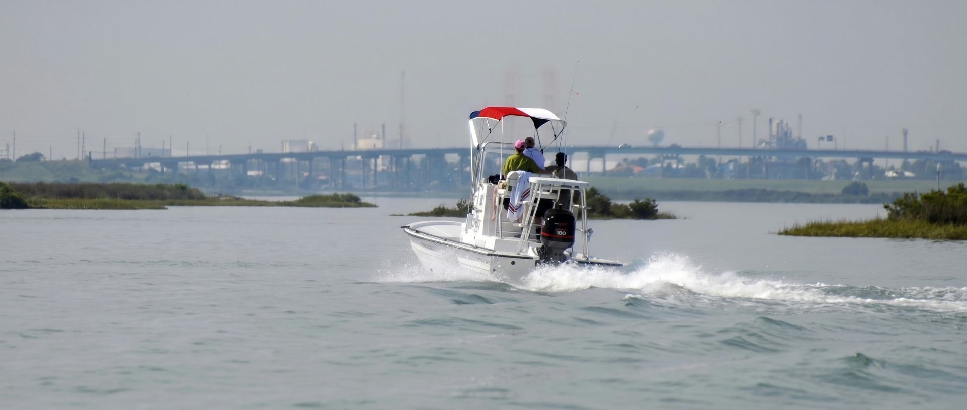 A bay boat running across the water under a Texas flag Canvas USA® Bimini T™