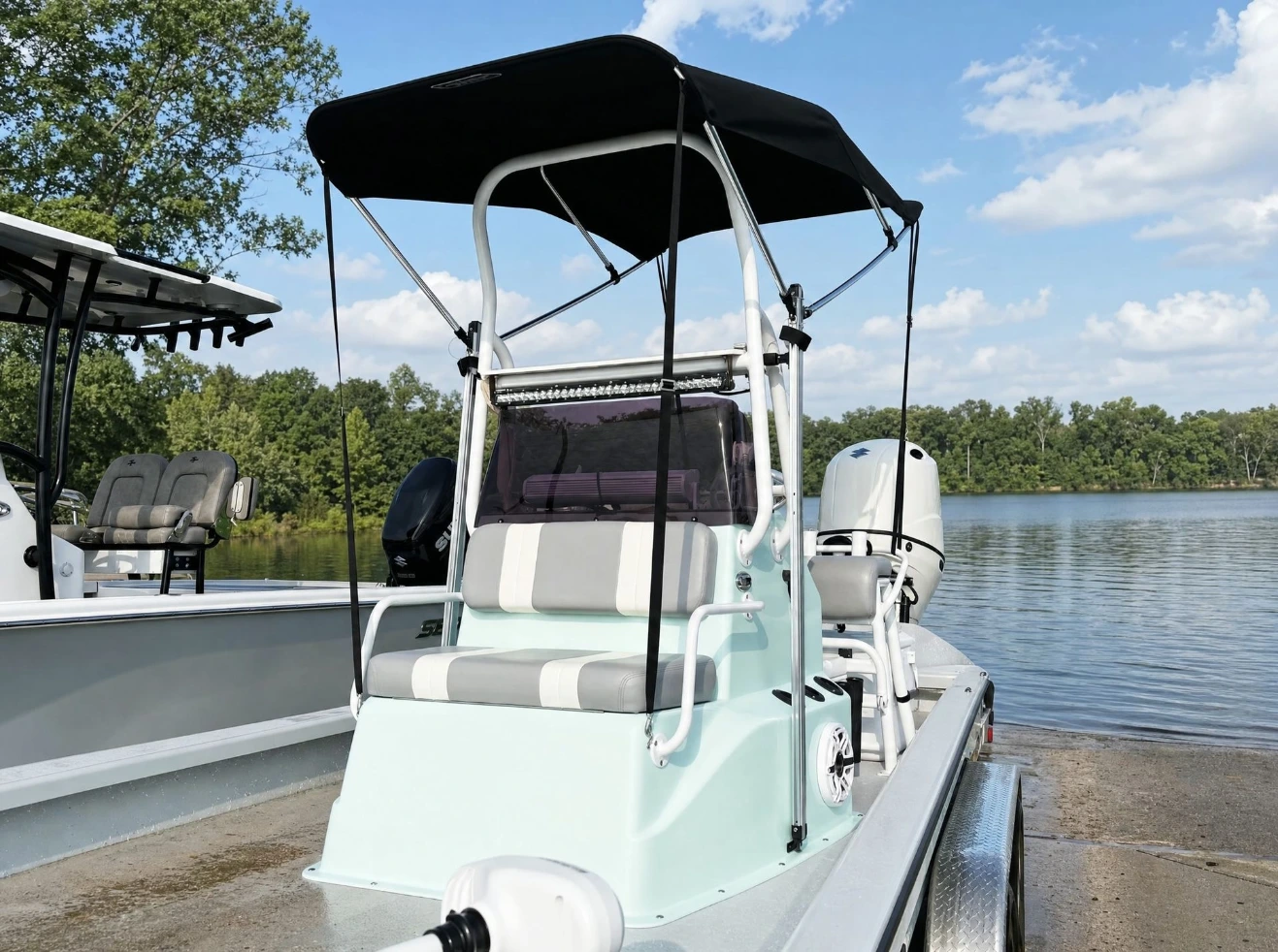 A black Canvas USA® Bimini T™ over the console of a bay boat at a launch ramp