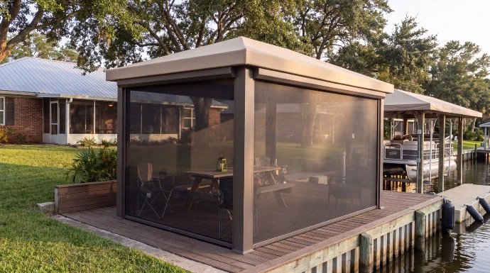 A screened cabana beside the water at a low waterfront home with a boat lift