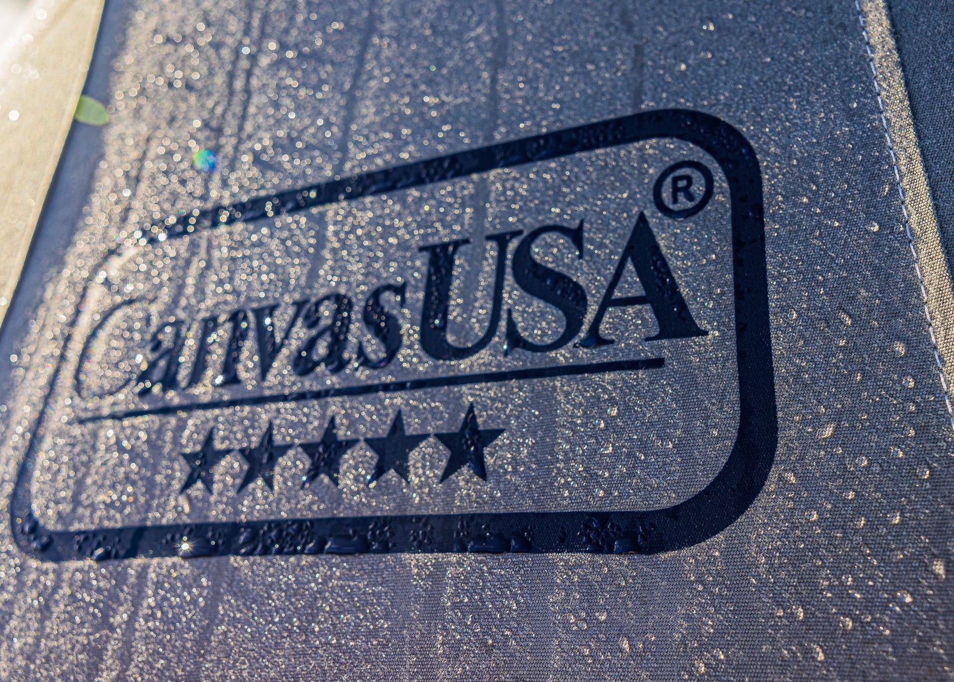 Water beading on dark canvas printed with the Canvas USA® logo