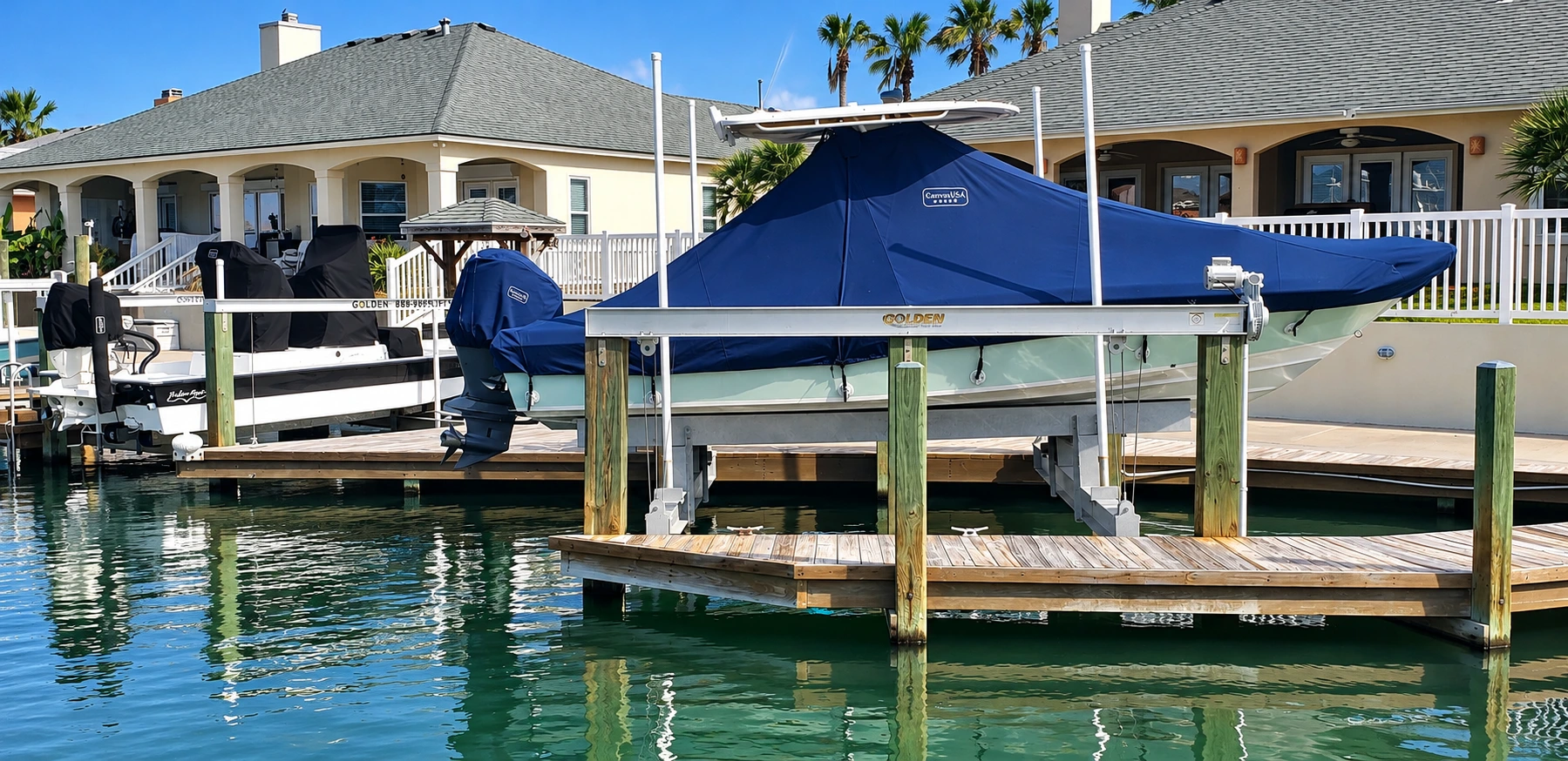 Grady-White and Shallowsport boats on lifts at a waterfront home under fitted navy and black Canvas USA® covers