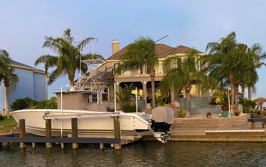 A Venture on its lift with fitted sand Canvas USA® console and outboard motor covers