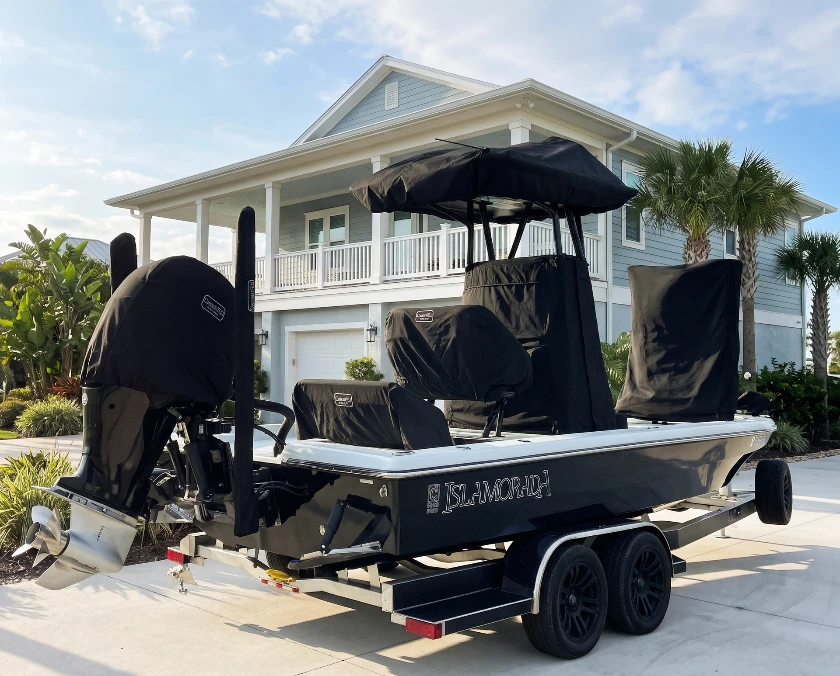 An Islamorada bay boat on its trailer with fitted black Canvas USA® motor, seat and console covers