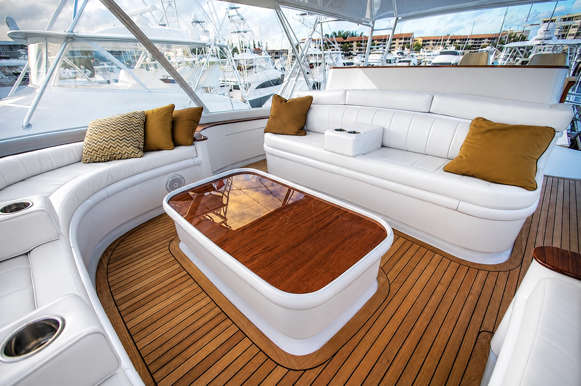 White Canvas USA® deck seating cushions with gold throw pillows on a yacht at the marina