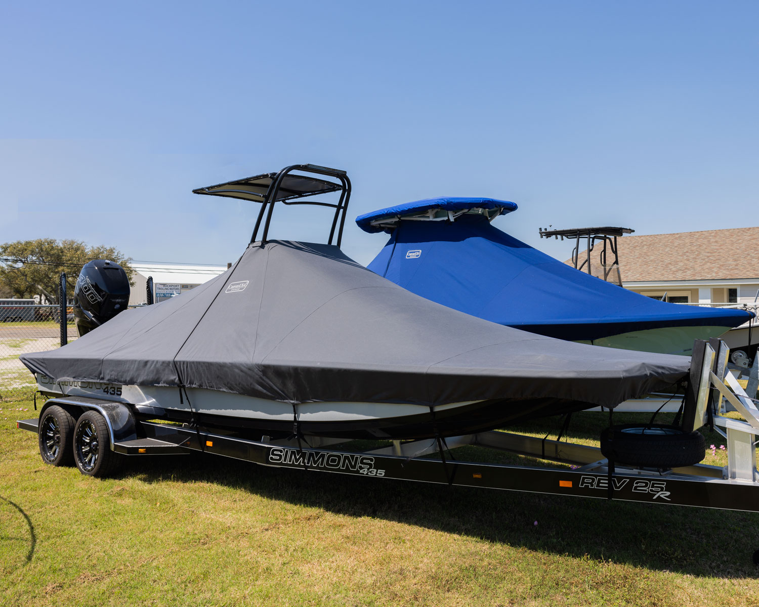 A Simmons boat under a fitted gray Canvas USA® full boat cover on its trailer