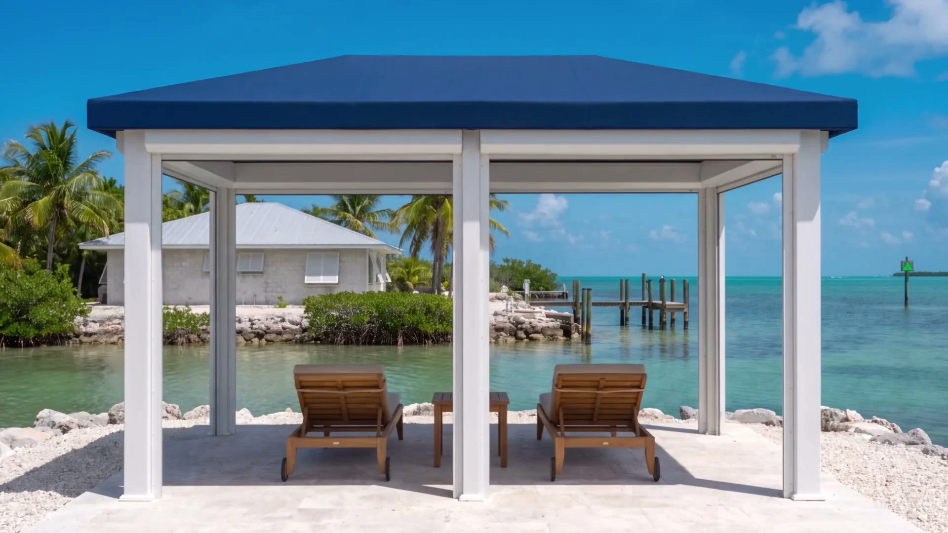 Navy-topped cabana with two teak loungers facing a waterfront dock